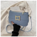 Close-up of light blue quilted crossbody bag with a square gold metal clasp for women - Blue