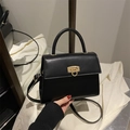 Elegante schwarze strukturierte Handtasche mit goldenem Drehverschluss und Schultergurt - Schwarz