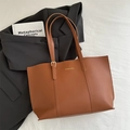 Dunkelbraune Leder-Tote-Bag mit Goldbeschriftung in einem professionellen Arbeitsumfeld - Braun
