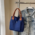 Bolso tote de lona azul con asas trenzadas marrones y detalle de hebilla metálica - Azul