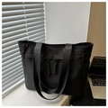 Detail of black canvas tote bag with side pockets on a professional office desk - Black