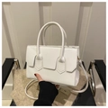 Dettaglio borsa bianca in ecopelle con patta decorativa tenuta su una sedia - Bianco