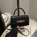 Elegant black faux leather crossbody bag with a gold buckle and round top handle - Black
