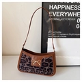 Detail view of the brown leather shoulder bag with leopard print and golden bow - Leopard Black