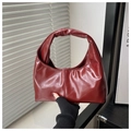 Dettaglio borsa hobo in pelle lucida rosso scuro con pieghe e consistenza morbida - Rosso