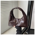 Dettaglio ravvicinato della borsa hobo a mezzaluna marrone scuro in pelle lucida e ombre - caffè