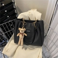 Large black leather tote bag with fashion patch, chain handles, and bear charm accessory - With Pendant / Black