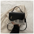 Détail du sac à main créatif piano avec imprimé clavier et fermoir métallique clé de sol doré - Noir