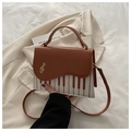 Détail du motif touches de piano et clé de sol dorée sur un sac bandoulière vintage - Marron