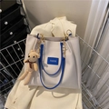 Cream tote bag with blue handles and a small brown knit bear charm on the strap - With Pendant / Blue
