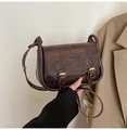 Detail of vintage brown leather crossbody bag with metal buckle and fashion logo - Coffee