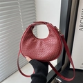 Bolso medialuna de cuero trenzado rojo oscuro con textura moderna y minimalista - Rojo