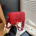 Red pebbled leather camera bag with wide geometric strap and The Mini Bag print - Red