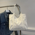 Minimalistische witte corduroy draagtas met voorvak getoond op denim achtergrond - Wit