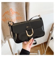 Close-up of shiny black patent leather shoulder bag with vintage gold horseshoe buckle - Black