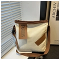 Detalle del bolso tote de lona con parche de cuero marrón, etiqueta de moda y correa tejida - Blanco
