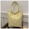 Detalle del bordado y las asas dobles resistentes en un bolso tote de lona amarillo claro - Amarillo
