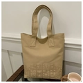 Primer plano detallado del bolso tote de lona caqui con bordado KTMU y textura de tela - Caqui