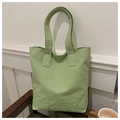 Detail of light green canvas tote bag showing reinforced stitching and subtle embroidery - Green