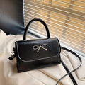 Elegante zwarte crossbodytas met een zilveren metalen strik en glanzende afwerking - Zwart