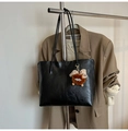 Detalle de bolso tote negro de cuero sintético con adorno en una percha de metal - Con Colgante / Negro