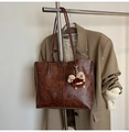 Detalle del bolso tote vintage en cuero marrón con textura de cera y colgante de peluche - Con Colgante / Marrón