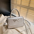 Elegante zilveren crossbodytas met een fijne metalen strik en leer met textuurafwerking - Zilver