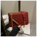 Détail d'un sac à chaîne bordeaux en cuir verni avec bordure dorée élégante - Rouge