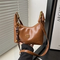 Brown leather crescent underarm bag with vintage metal logo and woven bell charm - Brown with Pendant