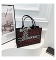 Detail van rode tote bag met luipaardprint, modieuze riem en sjaal aan het handvat - Rood
