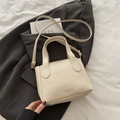 Minimalist beige pebble leather bucket bag with top handles and adjustable shoulder strap - White Without Pendant