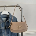 Beige Achseltasche mit goldener Schleife und Knotengurt in modischem Kontext gezeigt - Khaki