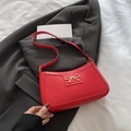 Bolso de hombro rojo estilo media luna con lazo dorado metálico y asa larga de cuero - Rojo