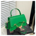 Detalle de bolso de cuero verde con cadena dorada sobre revista, escena con persianas - Verde