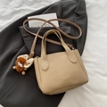 Khaki pebbled leather bucket bag with a cute brown monster plush charm and crossbody strap - Khaki With Pendant
