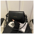 Detalle del bolso de hombro en cuero negro con correa anudada y letras doradas - Negro