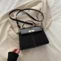 Classic black leather Kelly bag with white stitching and gold hardware on white blazer - Black