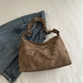 Brown marble pleated handbag with unique ruffled strap displayed on denim fabric - Brown