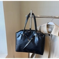 Dettaglio della borsa tote nera in ecopelle con fibbia metallica su supporto espositivo - Nero