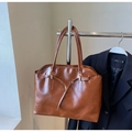 Dettaglio della borsa tote marrone caramello con trama lucida e fibbia decorativa - Marrone