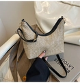 Gros plan d'un sac demi-lune en paille tressée avec bordure en cuir noir et zip en métal - Noir