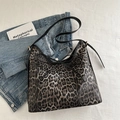 Borsa tote leopardata con fiocco nero e tracolla regolabile su uno sfondo lifestyle moderno - Nero