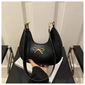 Detalle del bolso hobo negro con lazo metálico dorado y textura de cuero liso de alta calidad - Negro