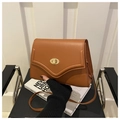 Dettaglio borsa a tracolla in pelle marrone con chiusura girevole dorata e patta - Marrone