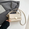 Minimalist cream rectangle crossbody bag with gold round buckle on grey blazer - Khaki