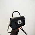 Bolso de mano de cuero negro con hebilla de pedrería brillante y detalles metálicos dorados - Negro