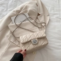 Chic cream-white quilted chain bag with silver twist lock on a matching blazer - Khaki