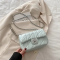 Chic mint green quilted crossbody bag with silver chain strap on cream blazer - Blue