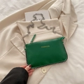 Emerald green crossbody bag with gold fashion text and metallic bead trim on white blazer - Green
