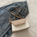 Bolso bandolera bicolor beige y blanco con cierre dorado sobre chaqueta vaquera - Caqui